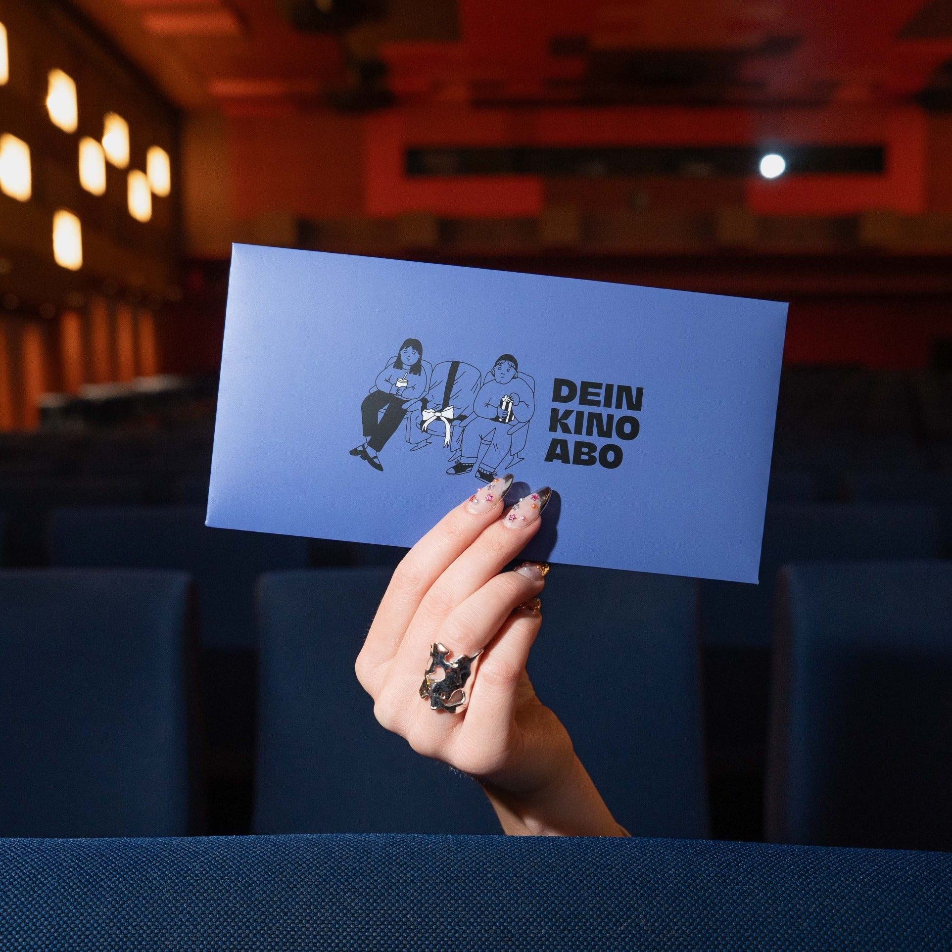 Gutscheinumschlag von Hand gehalten im Kino